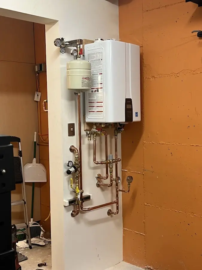 Plumbing technician inspecting water heater connections in Rockport
